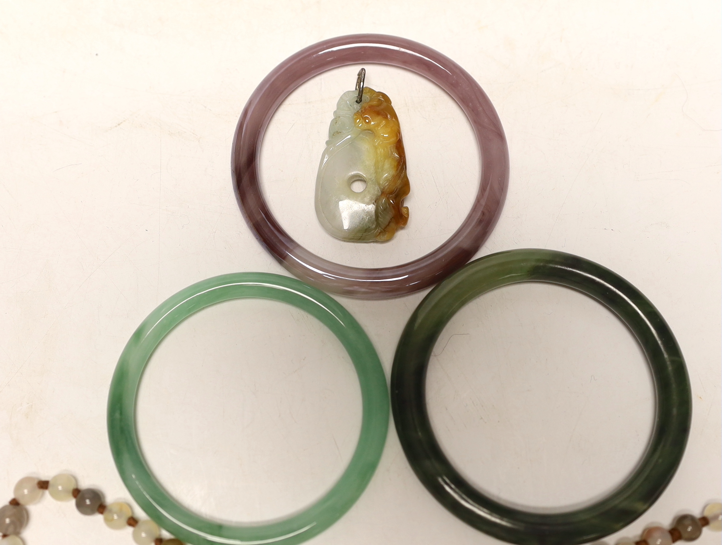 Two Chinese jade bangles, another, a jade pendant and beads